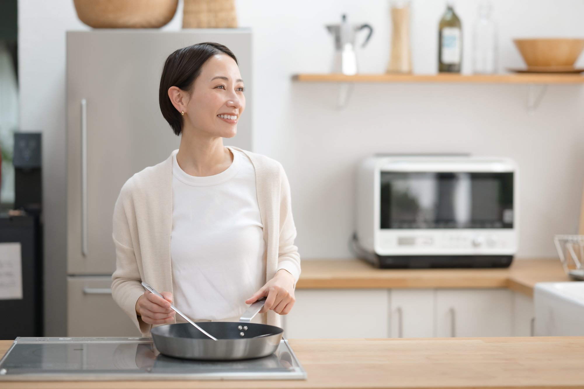 キッチンで料理する40代の女性
